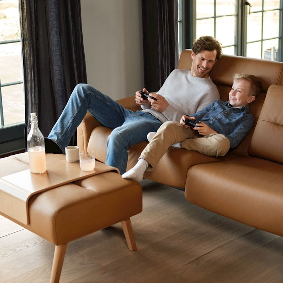 Man and boy gaming sitting in Stressless Stella sofa