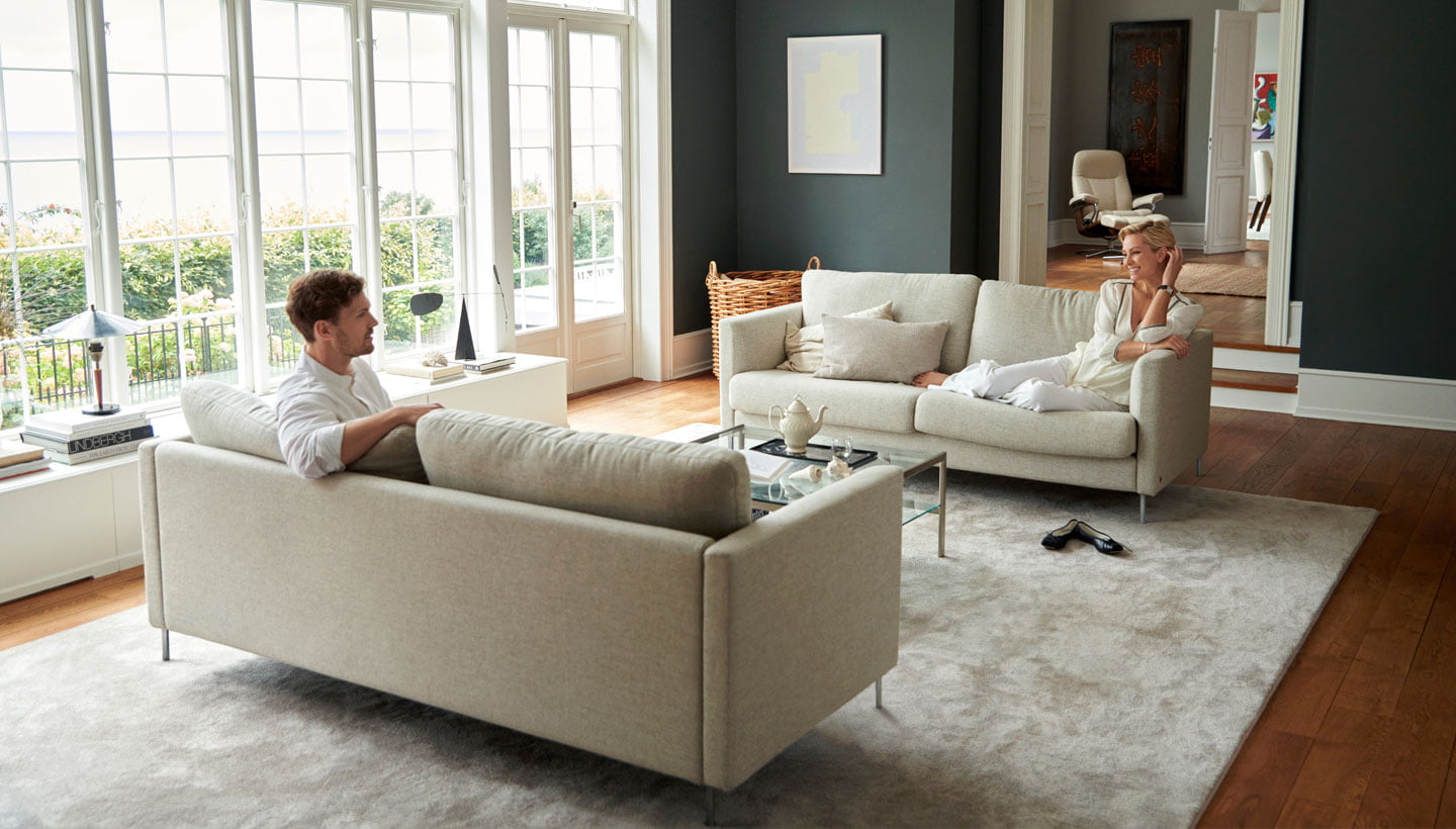 Man and woman sitting on Stressless® Copenhagen sofa
