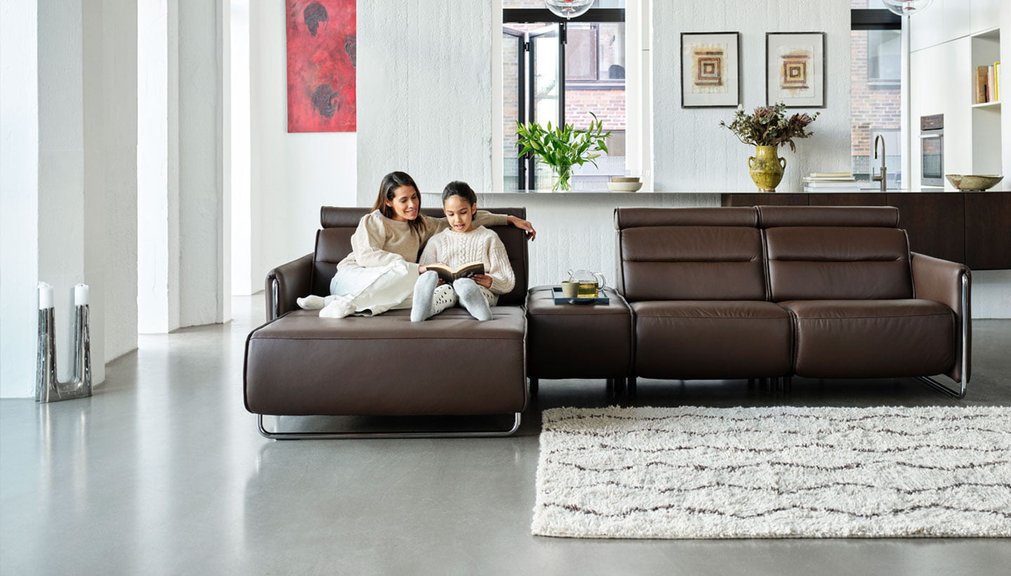 Madre e hija sentadas en el sofá motorizado Stressless® Emily