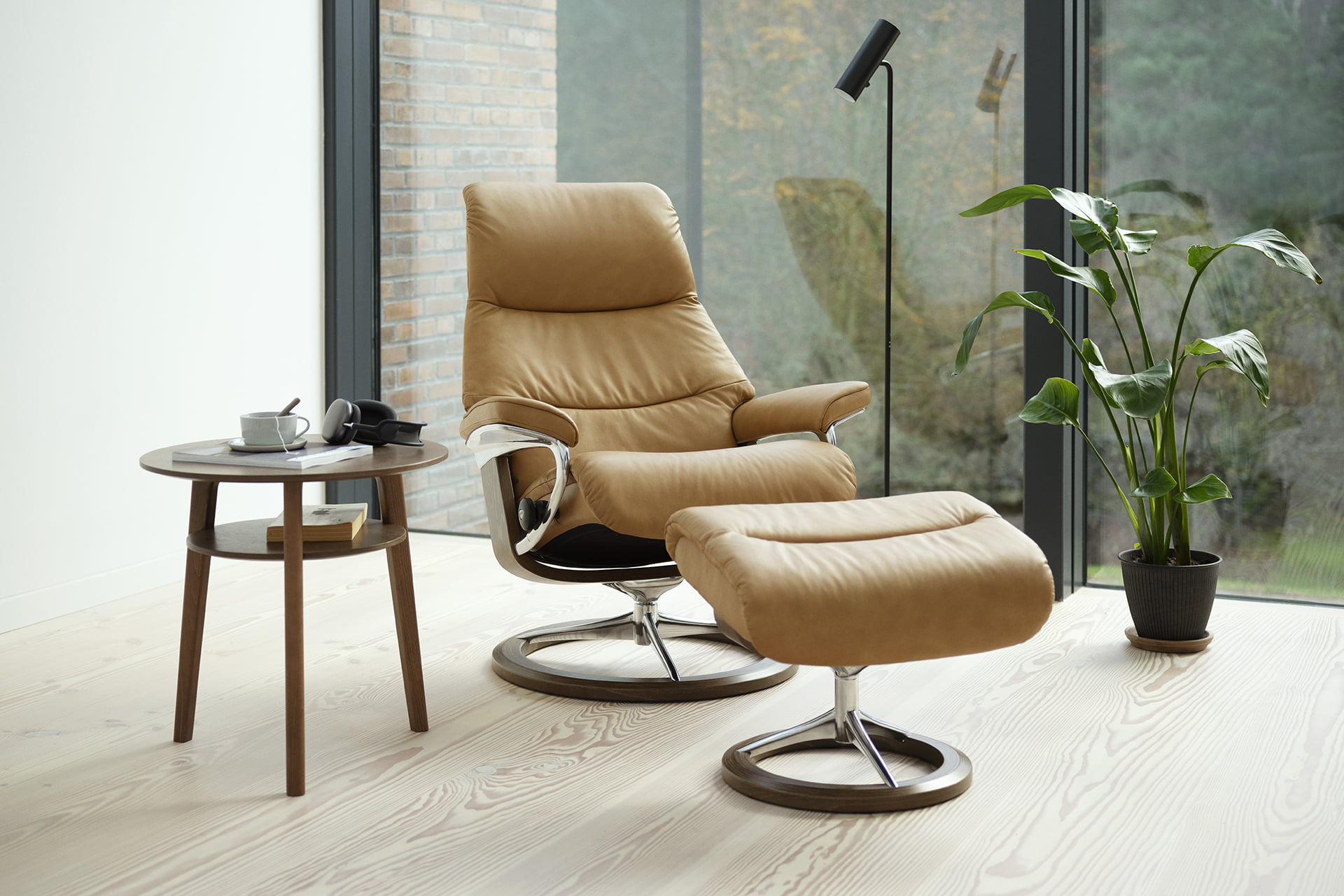 Stressless® View with a small round side-table in front of a large window