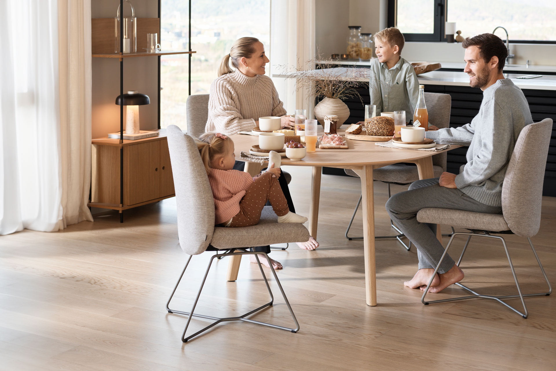 Family sitting at Stressless Basil Dining chairs around Stressless Bordeaux table
